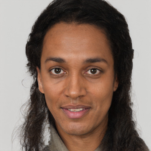 Joyful black adult female with long  brown hair and brown eyes