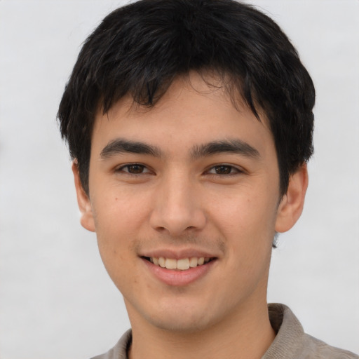 Joyful asian young-adult male with short  brown hair and brown eyes