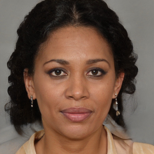 Joyful latino adult female with medium  brown hair and brown eyes