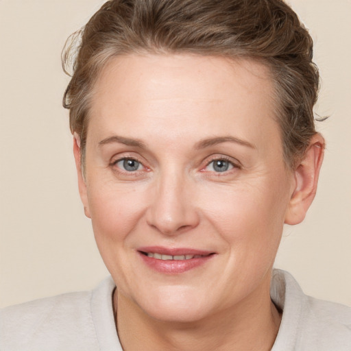 Joyful white adult female with short  brown hair and grey eyes