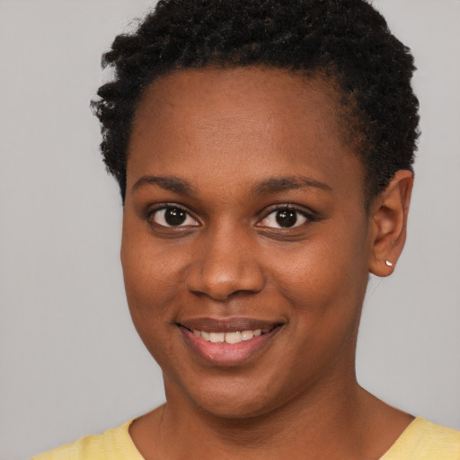 Joyful black young-adult female with short  brown hair and brown eyes