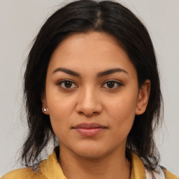 Joyful latino young-adult female with long  brown hair and brown eyes