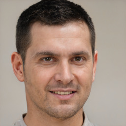 Joyful white adult male with short  brown hair and brown eyes