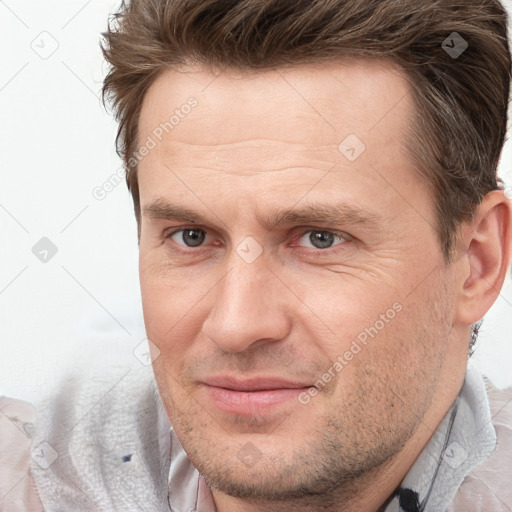 Joyful white adult male with short  brown hair and brown eyes