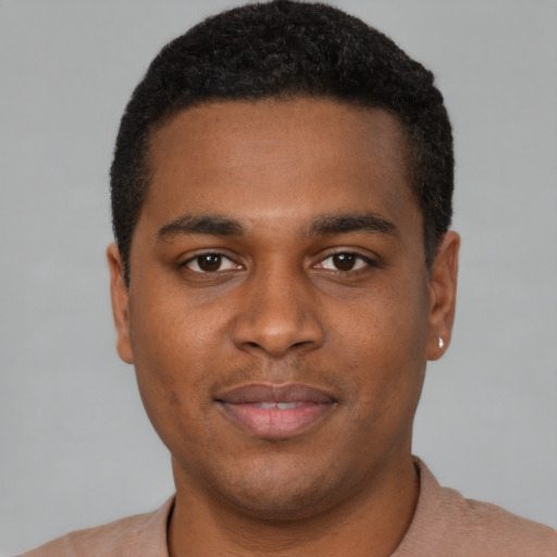 Joyful black young-adult male with short  brown hair and brown eyes