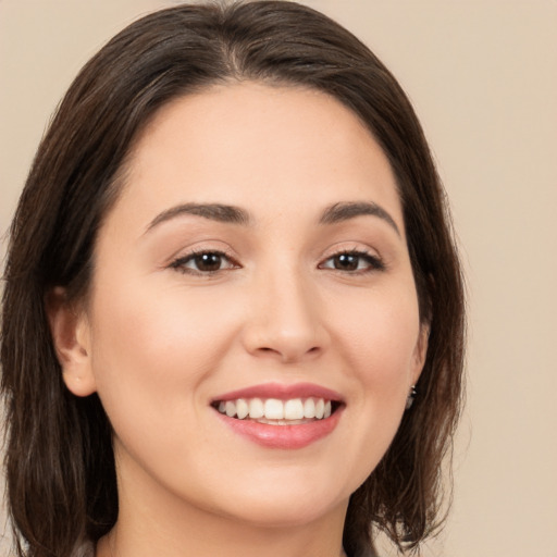 Joyful white young-adult female with long  brown hair and brown eyes