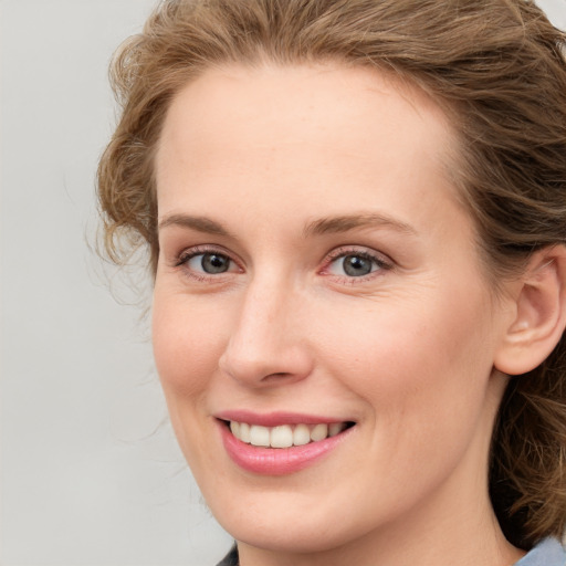 Joyful white young-adult female with medium  brown hair and blue eyes