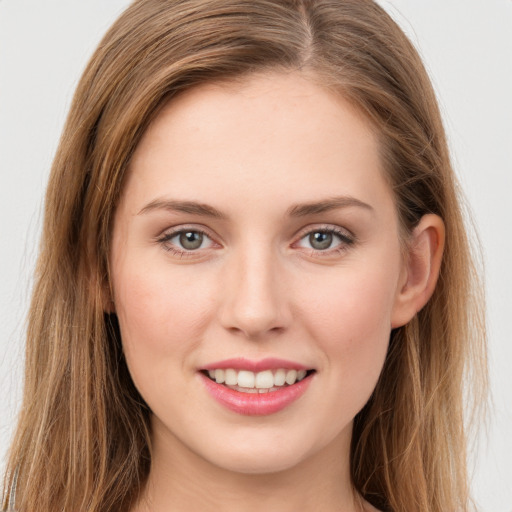 Joyful white young-adult female with long  brown hair and green eyes