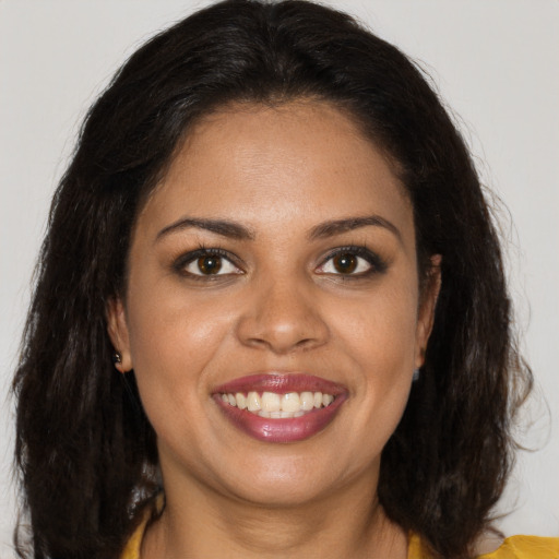 Joyful black young-adult female with long  brown hair and brown eyes