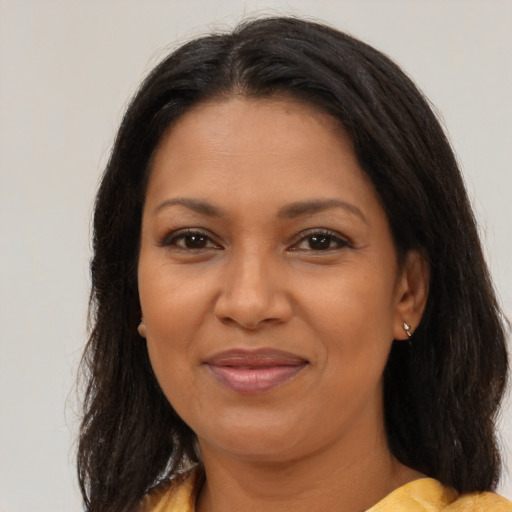 Joyful latino adult female with medium  brown hair and brown eyes