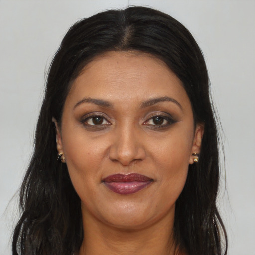Joyful black adult female with long  brown hair and brown eyes