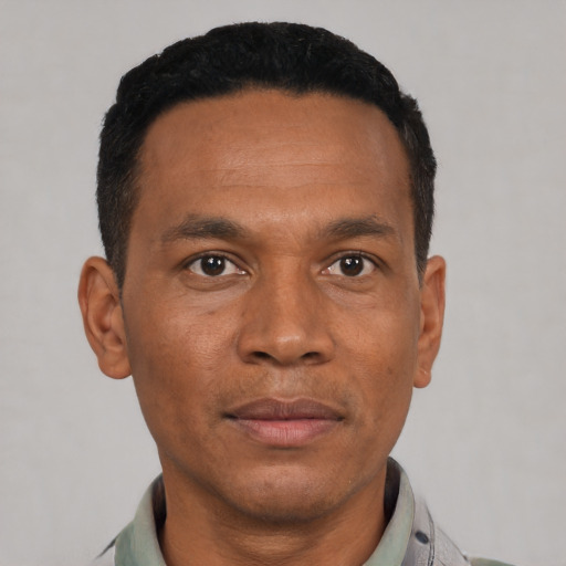 Joyful black adult male with short  black hair and brown eyes