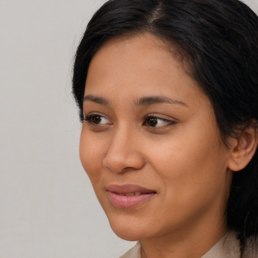 Joyful latino young-adult female with long  brown hair and brown eyes