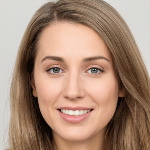 Joyful white young-adult female with long  brown hair and grey eyes