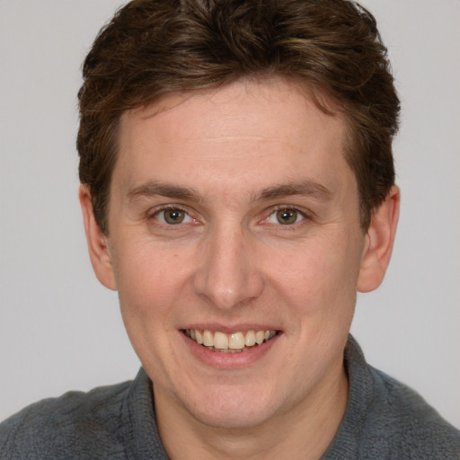 Joyful white adult male with short  brown hair and grey eyes