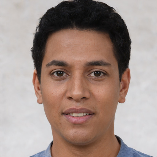 Joyful latino young-adult male with short  black hair and brown eyes