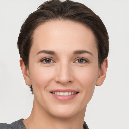 Joyful white young-adult female with short  brown hair and grey eyes