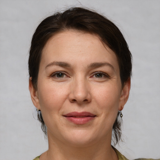 Joyful white adult female with medium  brown hair and brown eyes