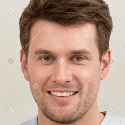 Joyful white young-adult male with short  brown hair and grey eyes