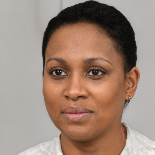 Joyful black young-adult female with short  black hair and brown eyes
