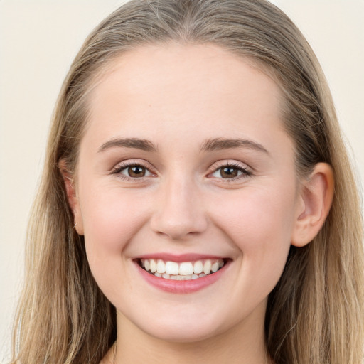 Joyful white young-adult female with long  brown hair and blue eyes