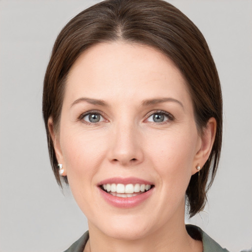 Joyful white young-adult female with medium  brown hair and grey eyes