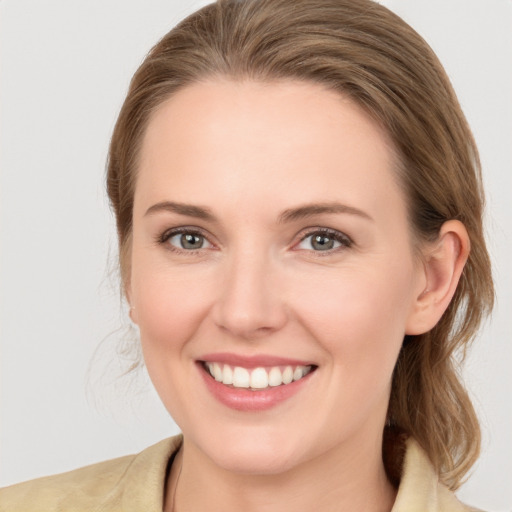 Joyful white young-adult female with medium  brown hair and grey eyes