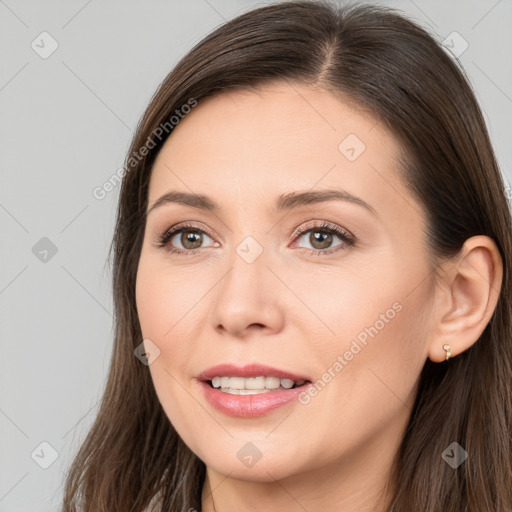 Joyful white young-adult female with long  brown hair and brown eyes