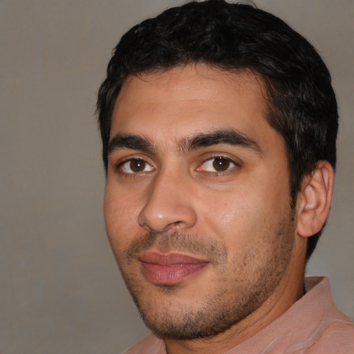 Joyful white young-adult male with short  black hair and brown eyes