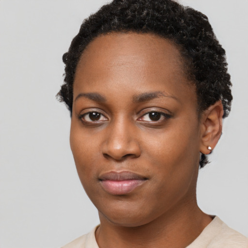 Joyful black young-adult female with short  black hair and brown eyes