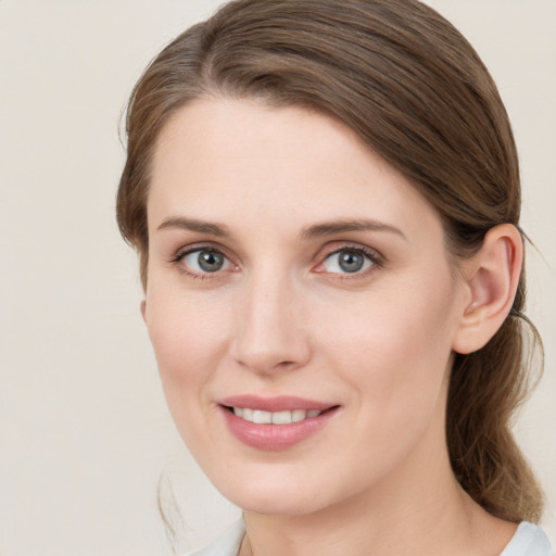 Joyful white young-adult female with medium  brown hair and grey eyes