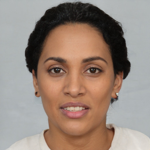 Joyful latino adult female with short  black hair and brown eyes