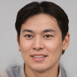 Joyful asian adult male with short  brown hair and brown eyes