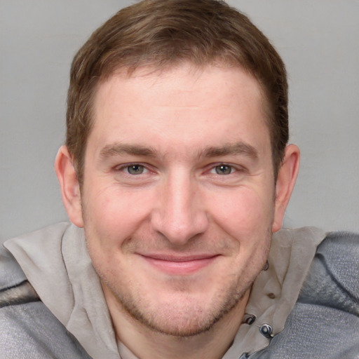 Joyful white young-adult male with short  brown hair and blue eyes