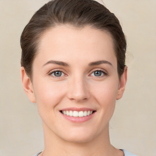 Joyful white young-adult female with short  brown hair and grey eyes