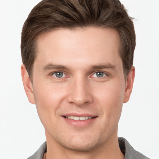 Joyful white young-adult male with short  brown hair and grey eyes