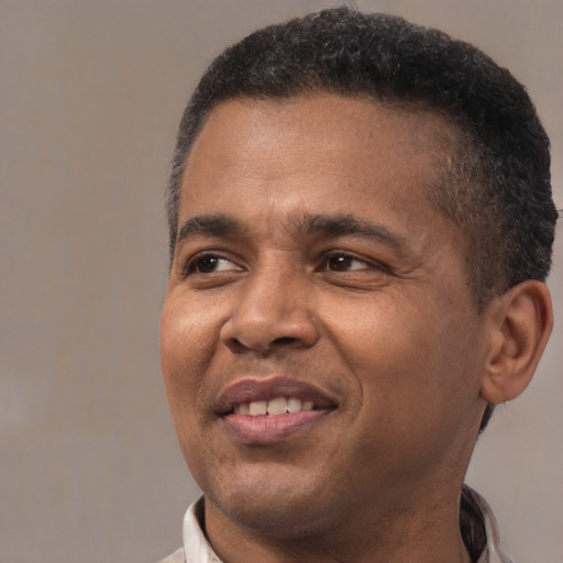 Joyful black adult male with short  brown hair and brown eyes