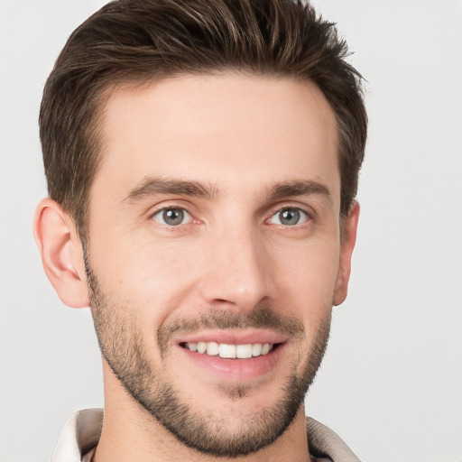 Joyful white young-adult male with short  brown hair and grey eyes