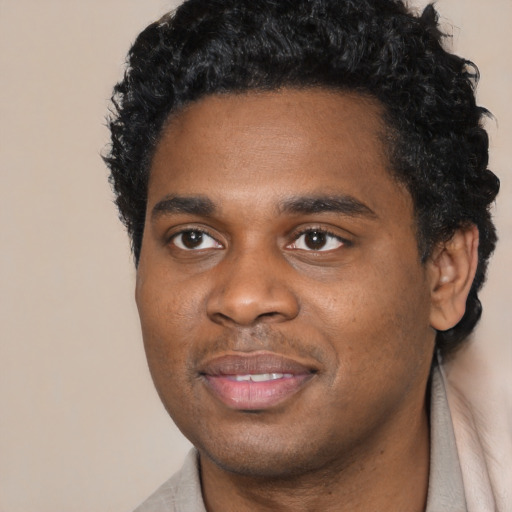 Joyful black young-adult male with short  black hair and brown eyes