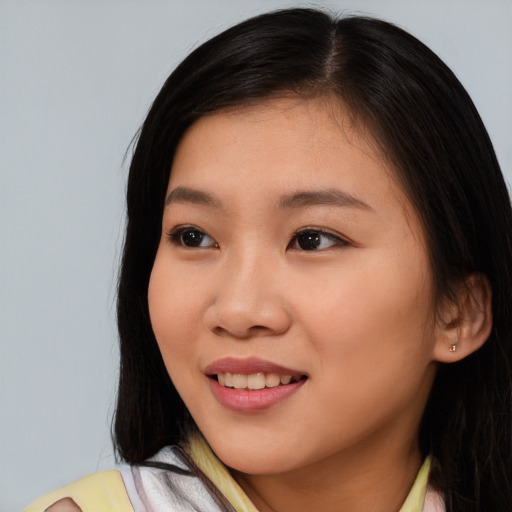 Joyful asian young-adult female with long  brown hair and brown eyes