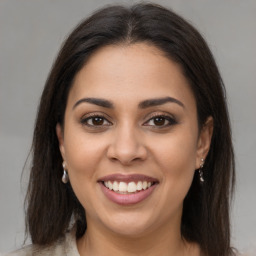 Joyful latino young-adult female with long  brown hair and brown eyes