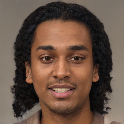 Joyful black young-adult male with short  black hair and brown eyes