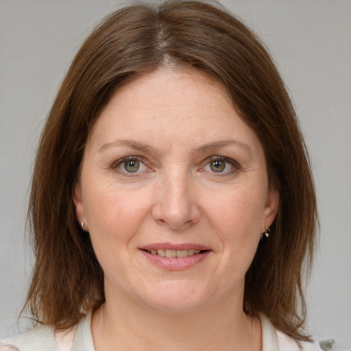 Joyful white adult female with medium  brown hair and grey eyes