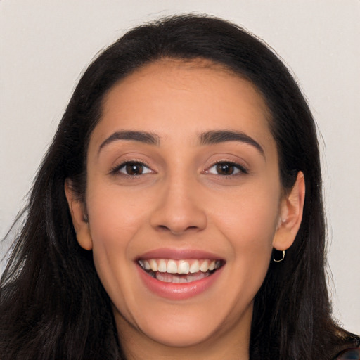 Joyful white young-adult female with long  black hair and brown eyes