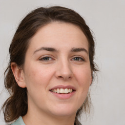 Joyful white young-adult female with medium  brown hair and green eyes