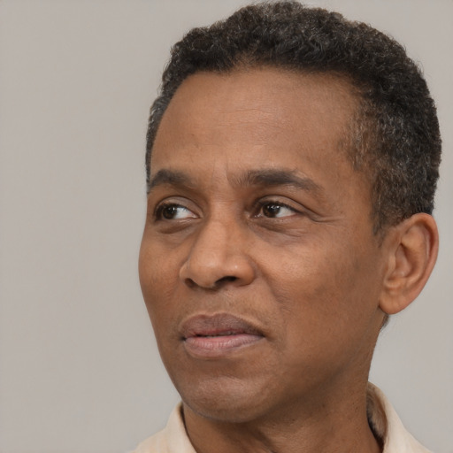 Joyful black adult male with short  brown hair and brown eyes