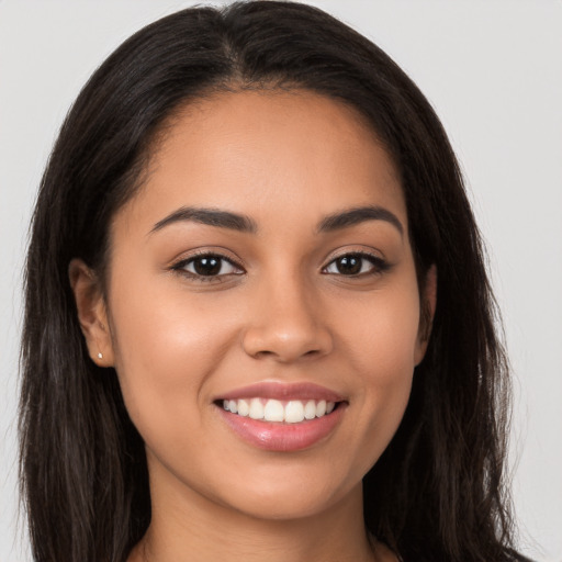 Joyful latino young-adult female with long  brown hair and brown eyes