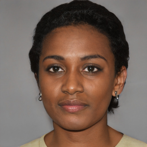 Joyful black young-adult female with short  black hair and brown eyes