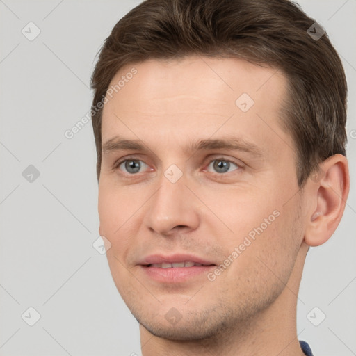 Joyful white young-adult male with short  brown hair and grey eyes