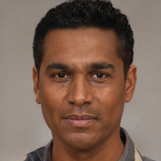 Joyful black adult male with short  black hair and brown eyes